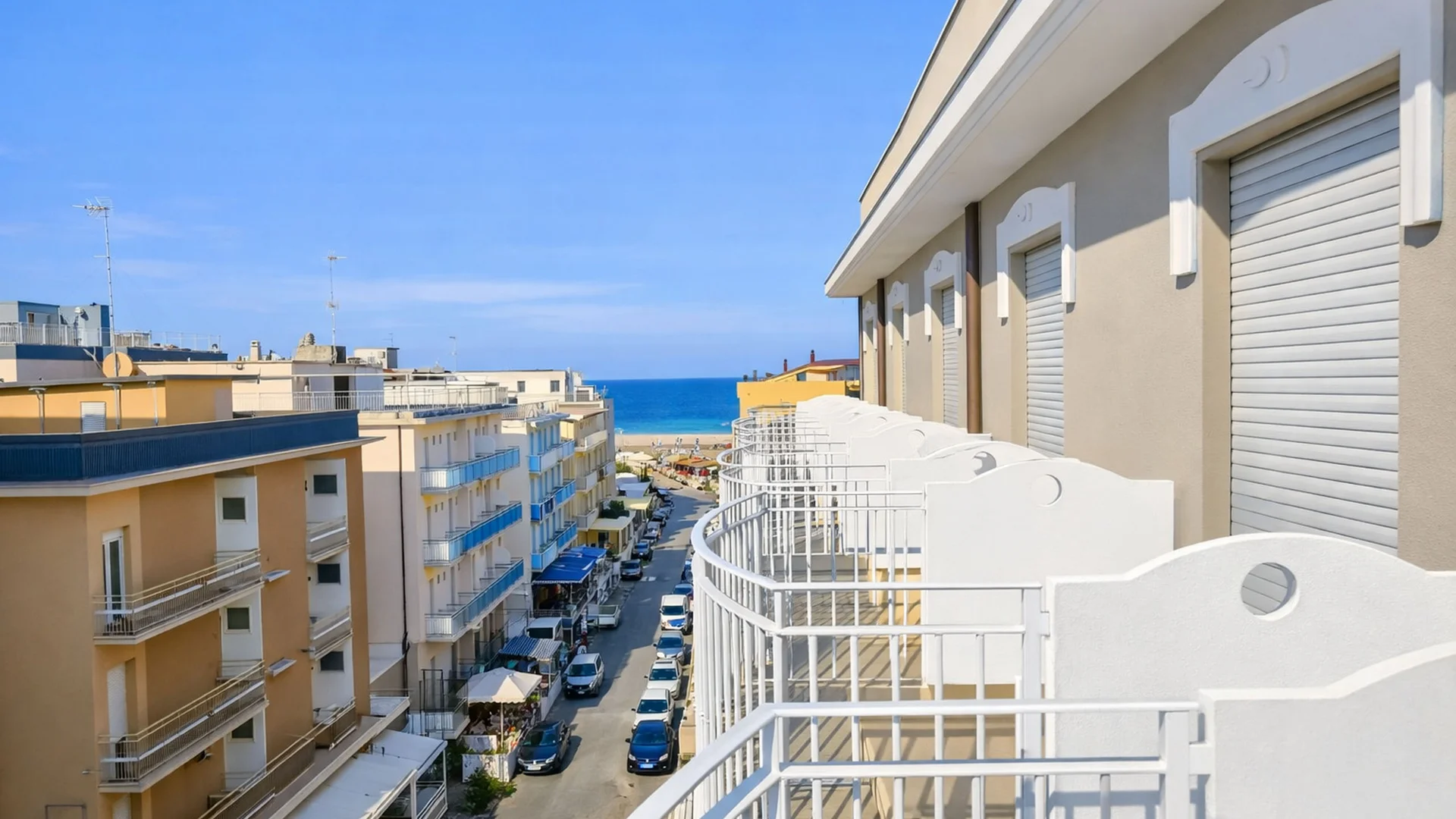 Hotel Regal: comfort ed eleganza a Rimini Vista di un balcone con ringhiera bianca che si affaccia su una strada verso il mare