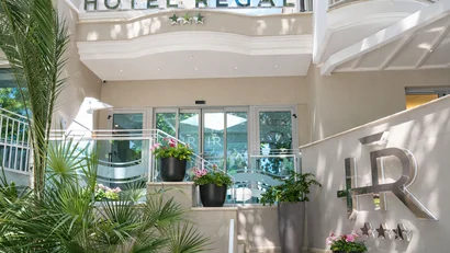 Hotel Regal: comfort ed eleganza a Rimini Ingresso moderno con piante e segnale Hotel Regal a tre stelle