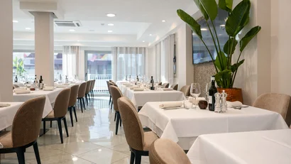 Hotel Regal: comfort ed eleganza a Rimini Interno moderno e luminoso di ristorante con tovaglie bianche e sedie beige