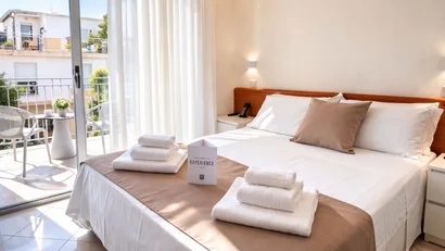 Hotel Regal: comfort ed eleganza a Rimini Camera d'hotel luminosa con letto sistemato, asciugamani bianchi e balcone con sedie