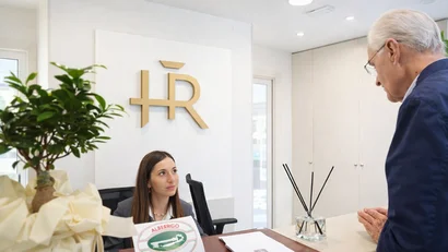 Hotel Regal: comfort ed eleganza a Rimini Receptionist donna parla con anziano ospite alla reception dell'hotel