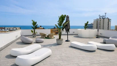 Hotel Regal: comfort ed eleganza a Rimini Terrazza con sedute bianche moderne e vista mare su cielo limpido